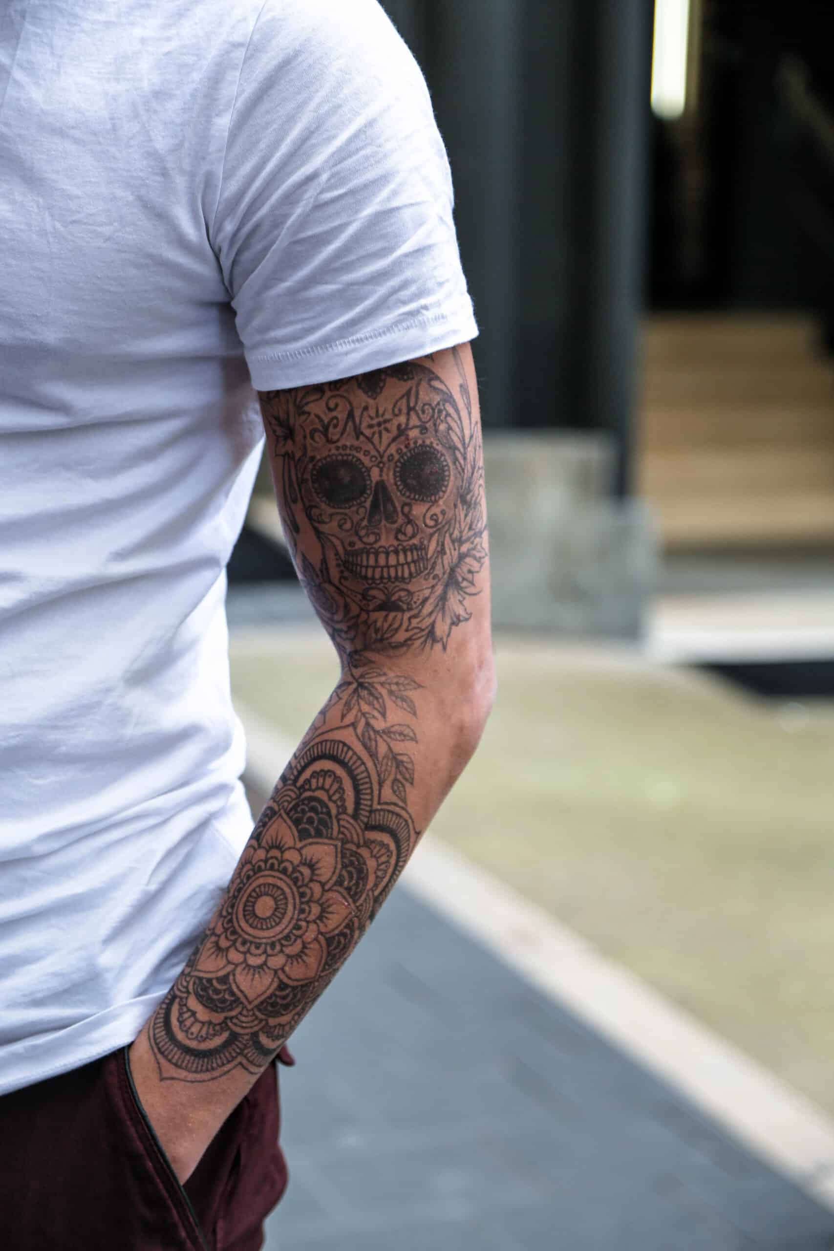 Tatouage éphémère au jagua sur le bras, motif mandala et crâne ornemental, rendu proche d’un tatouage permanent